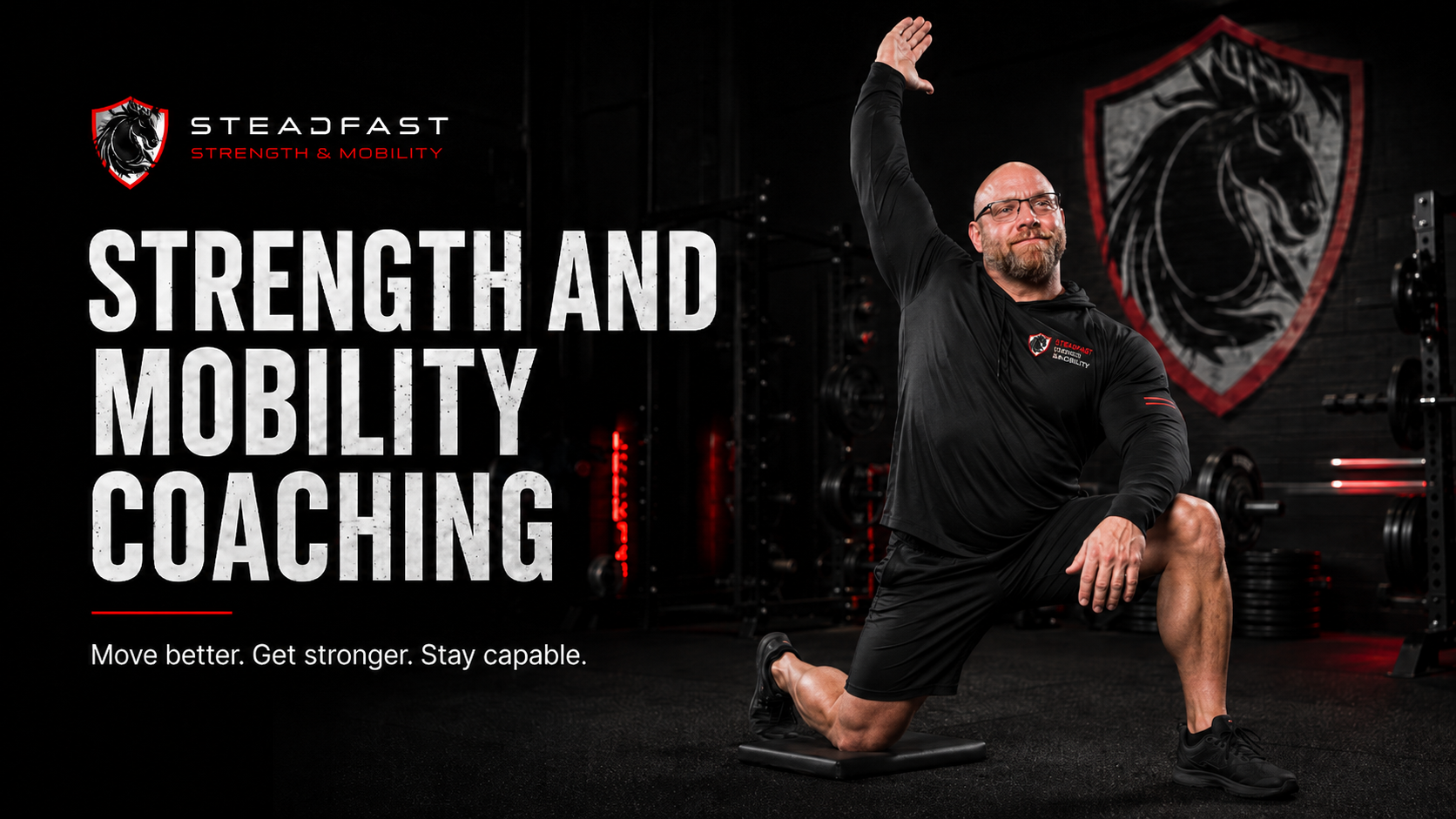 Steadfast Strength and Mobility coach demonstrating a kneeling strength and mobility stretch in a dark gym.
