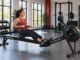 Woman using a Concept2 rowing machine in a naturally lit gym.